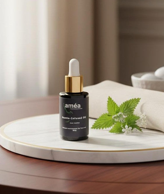 Améa Nettle-Infused Oil — 30 ml dropper bottle resting on dried Irish nettle leaves